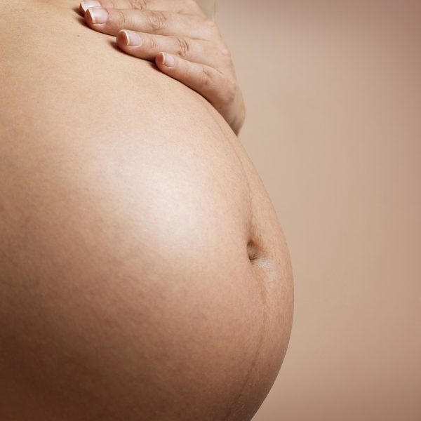 Femme enceinte recevant un massage pré-natal au Centre de soins Naxane pour apaiser les tensions physiques et émotionnelles.