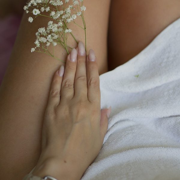 Main posée sur des jambes relaxées, symbolisant la légèreté et la détente procurées par le massage Pagatchampi au Centre Naxane, un soin de 30 minutes pour revitaliser les jambes.