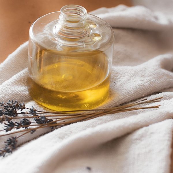 Flacon d’huile de massage et lavande, utilisés pour les massages relaxants au Centre de soins Naxane près de Saint-Chamond.